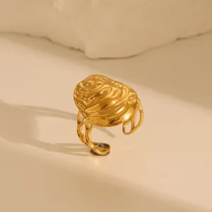 Macro detail of golden wave textured ring with openwork design and lava style finish