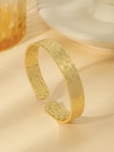 Vista dettagliata del bracciale aperto placcato oro 18k con trama di metallo intrecciato