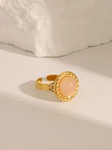 Detail of 18K gold-plated ring with a pink round gemstone and adjustable twist band