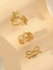 Detailed macro view of 18k gold plated stainless steel rings with leaf and bow designs