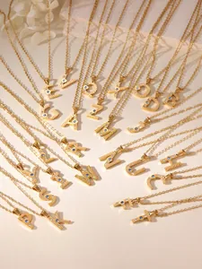 Detailed view of gold initial necklaces with zircon inlay and radial texture patterns