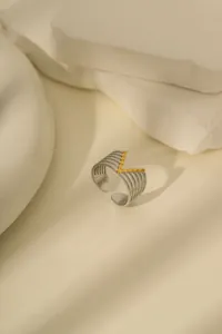 Makro-Detail von mehrlagigen Silberringen mit Goldperlen in elegantem V-Form-Design
