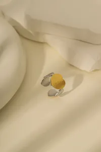 Detail eines zweifarbigen Herzrings aus Gold und Silber mit Hammerschlag-Textur und offenem Band