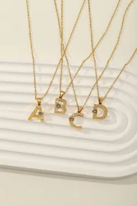 Detailed view of gold letter pendants A-D with radial texture and sparkling zircon stones