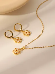 Macro-detail van 18k vergulde bloem ketting en oorbellen set met sprankelende zirkonen
