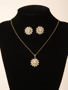 Detailopname van sprankelende bloemenhanger en oorknoppen set met 18k gouden plating