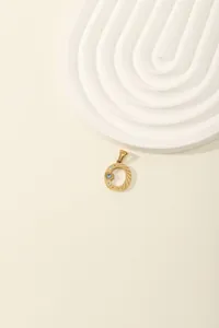 Detail of gold letter O pendant with sparkling blue and white zircon stones inlay
