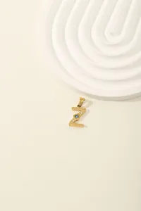 Detailed macro view of gold letter Z pendant with blue stone and cubic zirconia inlay