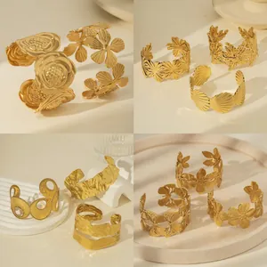 Selection of golden wide open cuff bracelets with floral patterns and hammered texture