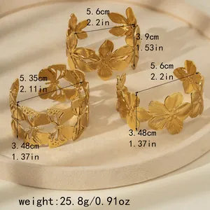 Detailed view of irregular hammered gold bangles with floral and butterfly motifs
