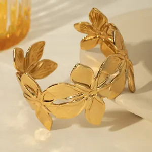 Detail view of the golden floral cuff bracelet with textured petals and open adjustable design