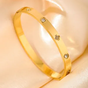 Gold-plated stainless steel bangle featuring clover patterns and sparkling rhinestones
