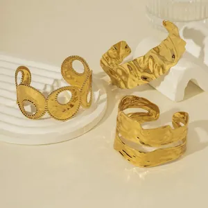 Three gold hammered texture open bangles on minimalist stone podium display