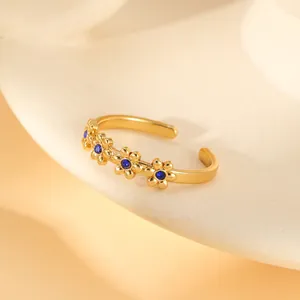 Macro detail of gold-plated flower ring with blue zircon inlay and open band