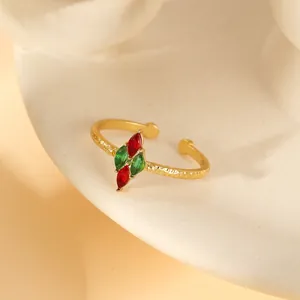 Detail of adjustable gold ring with hammered texture and marquise-cut red green stones