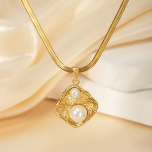 Detail showing 18k gold hammered pendant with two pearls on a herringbone snake chain