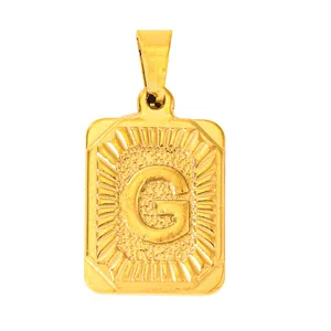 Macro shot of gold-plated rectangular pendant with embossed letter G and sunray texture