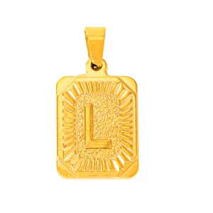 Macro detail of gold plated rectangle pendant with embossed letter L and textured finish