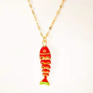 Macro detail of red enamel koi fish pendant with gold scales and fine golden chain