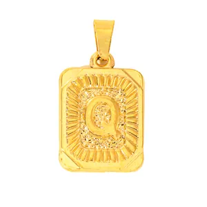 Macro detail of gold-plated square pendant featuring embossed letter Q with sunburst texture