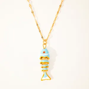 Close-up of a 18k gold-plated koi fish pendant with colorful enamel and a red gemstone eye