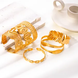 Dettaglio di vari bracciali in acciaio inossidabile placcati oro 18k con trame geometriche