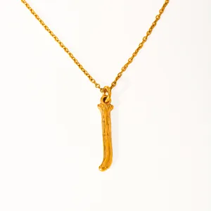 Detail of 18k gold plated stainless steel letter necklace with textured tree bark finish