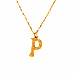 Macro view of textured 18k gold plated letter P pendant on a fine link chain necklace