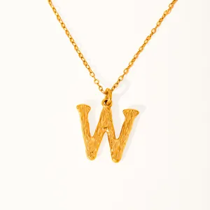 Detail of 18k gold plated letter W pendant with vintage textured finish on thin chain