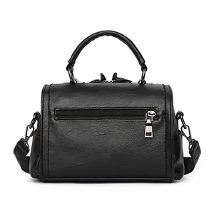 Black pebbled PU leather Boston bag with top handles and rear zipper pocket on white background
