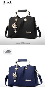 Close-up of black and royal blue leather handbags with metal handles and petal charms