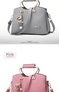 Detail of pink and grey faux leather handbags with metal handles and floral charms