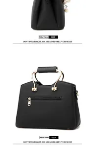 Detail of black pebbled leather handbag featuring gold metal handles and a rear zipper pocket