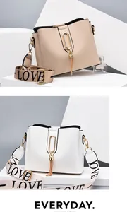 Close-up of leather bucket bag with gold chain tassel and LOVE patterned wide strap