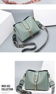 Detail of light green crossbody bag with gold buckle tassel and LOVE embroidered strap
