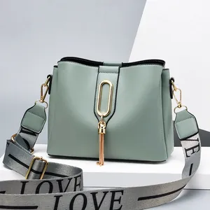 Sage green bucket bag with golden tassel ring and wide LOVE jacquard shoulder strap