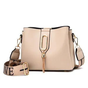 Fashionable beige PU crossbody bag with gold buckle tassel and LOVE letter strap