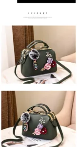 Detail of dark green leather handbag with 3D floral accents and fuzzy ball charm