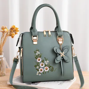 Elegante borsa a tracolla grigio-verde con ricami floreali e ciondolo a farfalla