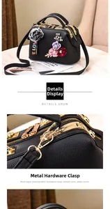 Detail of lychee pattern leather bag with pink floral accents and gold hardware