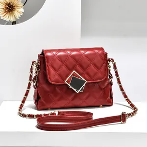 Chic dark red quilted chain shoulder bag with elegant gold square buckle on white podium