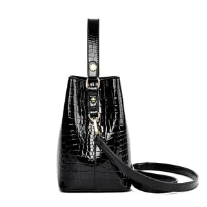 Glossy black crocodile pattern bucket bag with gold hardware and detachable shoulder strap
