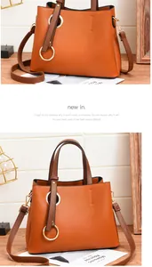 Detail of caramel PU leather handbag with decorative golden metal rings and shoulder strap