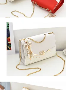 Detail of white chain bag with heart buckle, glitter sequins, and pearl bow charm