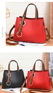 Detail of red and black PU leather handbags with golden ring decor and long shoulder straps