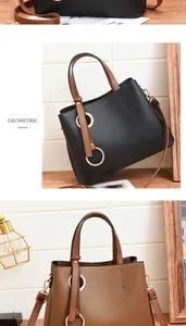 Detail of geometric PU leather handbag showing metal ring accents and contrast handles