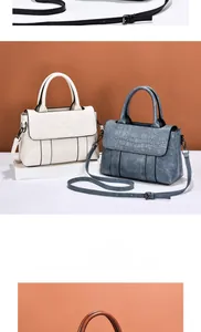 Détail de deux sacs à main en cuir blanc et bleu-gris avec rabat en relief crocodile