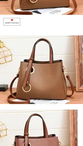 Detail of classic brown PU leather tote with decorative gold ring and adjustable strap