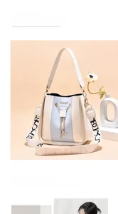 Close-up detail of the elegant light blue and beige bucket bag with a gold chain