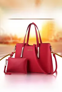 Dettaglio del set di borse rosse con trama litchi, hardware dorato e pochette abbinata